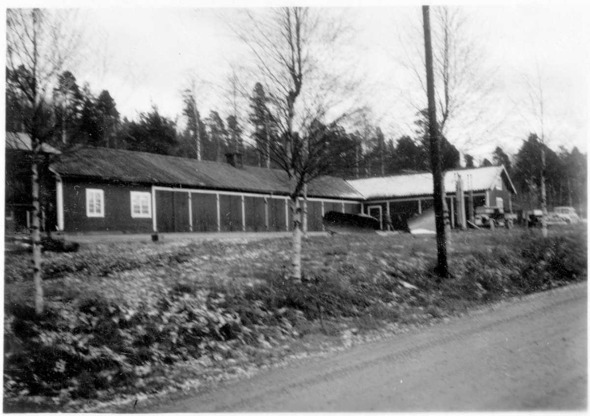 Vägstation E13, Stjärnvik. Garagelänga och förrådsbyggnad byggd i vinkel. Spetsplogar, personbil och lastbil.