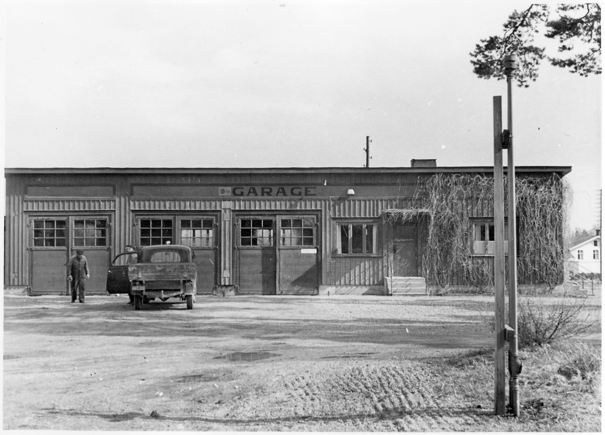 Vägstation T4, Svartå, filial Kvistbro. Garagebyggnad, med text ovanför portarna "Garage", kontor till höger, eventuellt tjänstebostad för vägmästaren i högra gaveldelen. Liten lastbil (paketbil) framför garaget, två manspersoner i anslutning till lastbilen. 