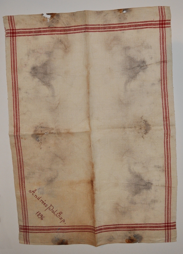 Fyra handdukar i linne med röda bårder. Broderade i stjälkstygn med rött garn, "Andrées Pol. Exp. 1896". Terasiga och fläckiga. Vikta.