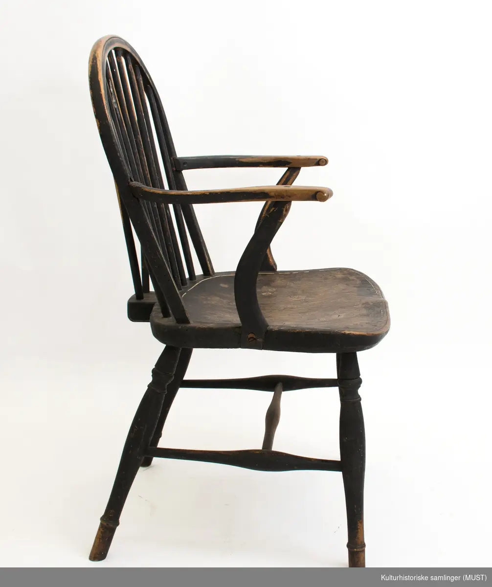 Sortmalt stol med hvit strekdekor. Stolen er bøyet og sveifet. 
Dreide bein, sveifete armlen og armlenstøtter. Dreide bein og sprosser. 
Ryggen består av avsmalede spiler. 
H-kryss og dreide sprosser.