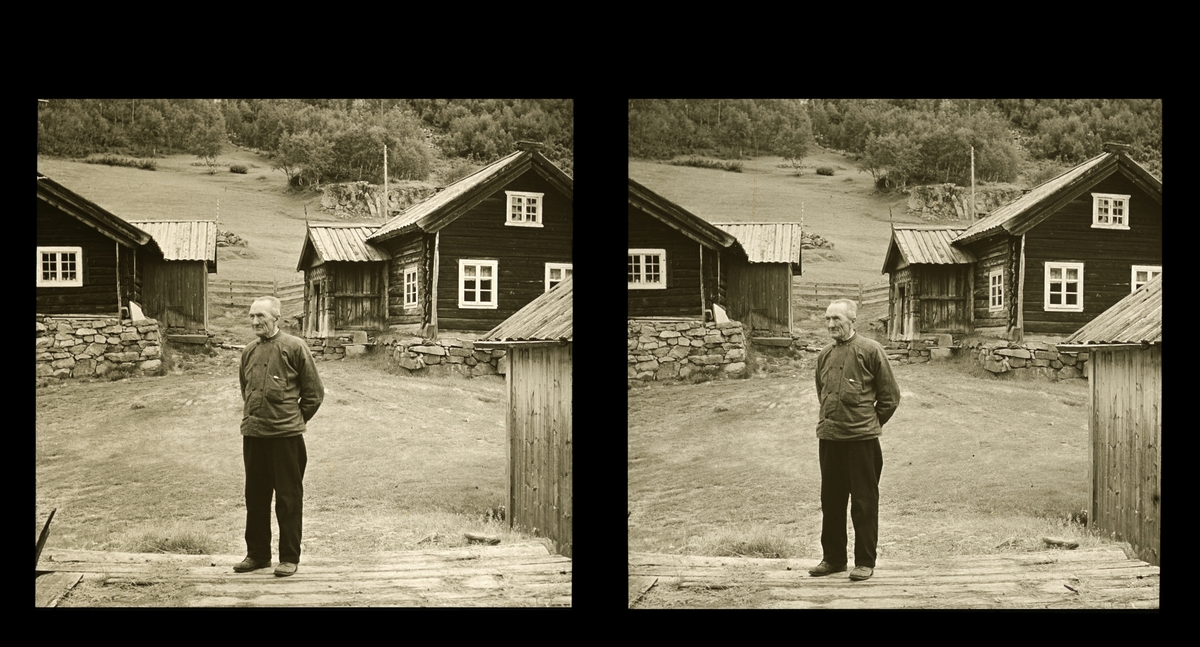 En eldre mann står ute på gårdstunet. På tunet ligger to laftede stuer. Tilhører Arkitekt Hans Grendahls samling av stereobilder.