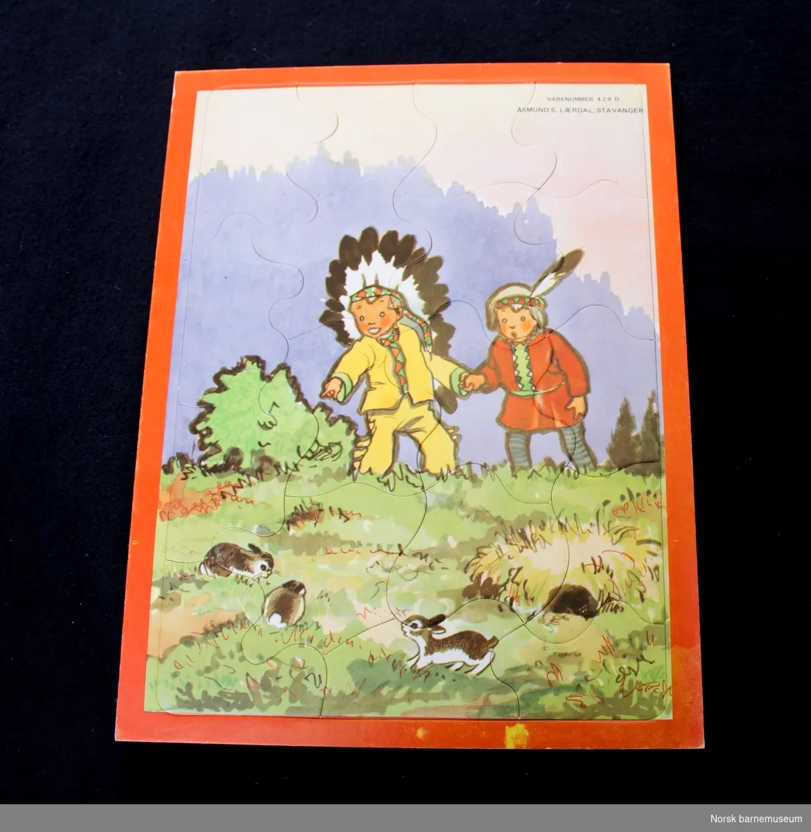Puslespillet er bilde av to barn som leker indianere og ser på kaniner. 