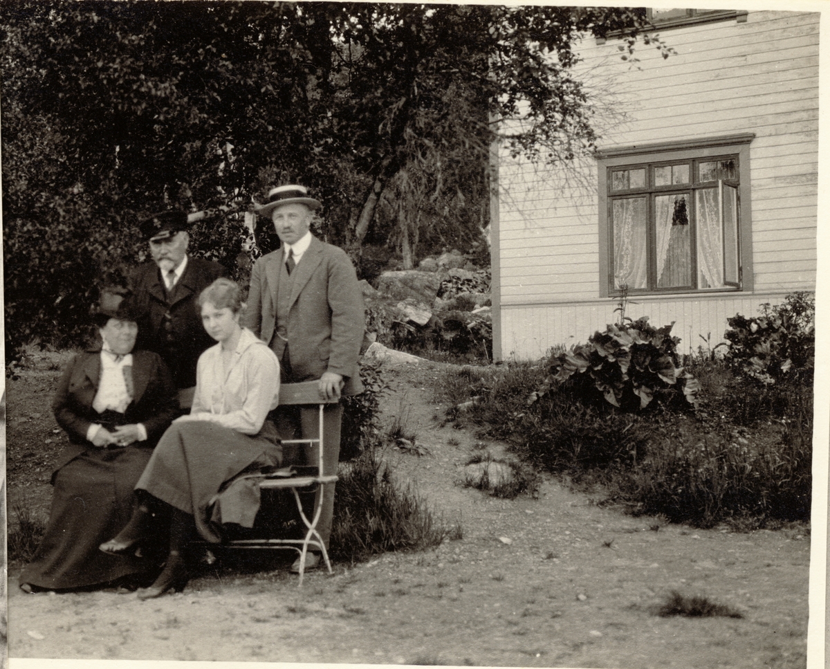 Et reisefølge på vei fra Kongsberg til Geilo avbildet i hage. Bak står Ch.(?) Reimers og Westye P. Egeberg og foran sitter fru Reimers og Evelyn Egeberg. Fotografert juli 1916.