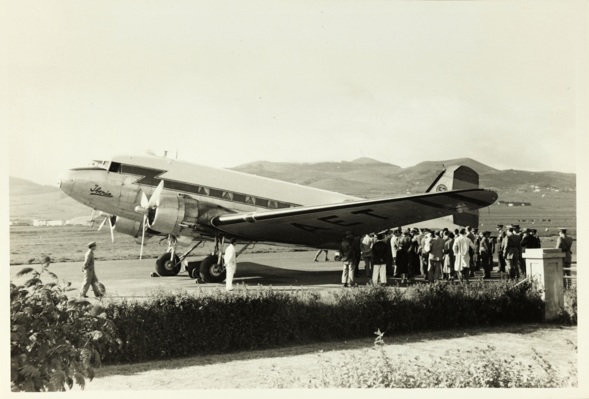 En gruppe mennesker venter på å komme ombord på fly, antagelig på Tenerife. Trolig fotografert under reise i 1953.