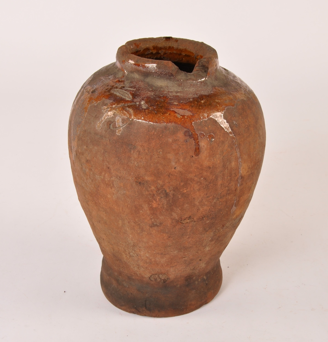 Dreid krukke i keramikk med fotrand og munningsrand. Sylinderformet med bredere form opp mot munningen. Glasurrester på utsiden. Glasert innside.