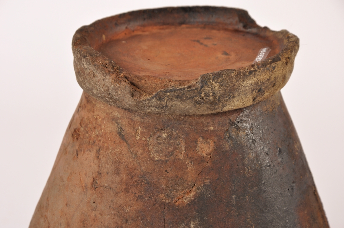 Dreid krukke i keramikk med fotrand og munningsrand. Sylinderformet med bredere form opp mot munningen. Glasurrester på utsiden. Glasert innside.