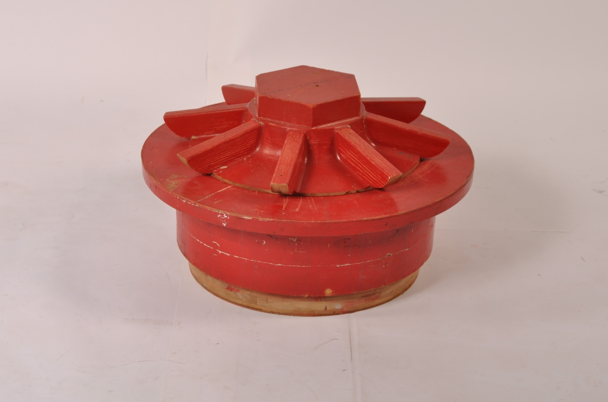 Modell i 3 deler, laget i tre, rødmalt. Del 1-mutterform 8 eiker, del 2- rund krage med 8 utstikkere, del 3- rund base med fot og hull.