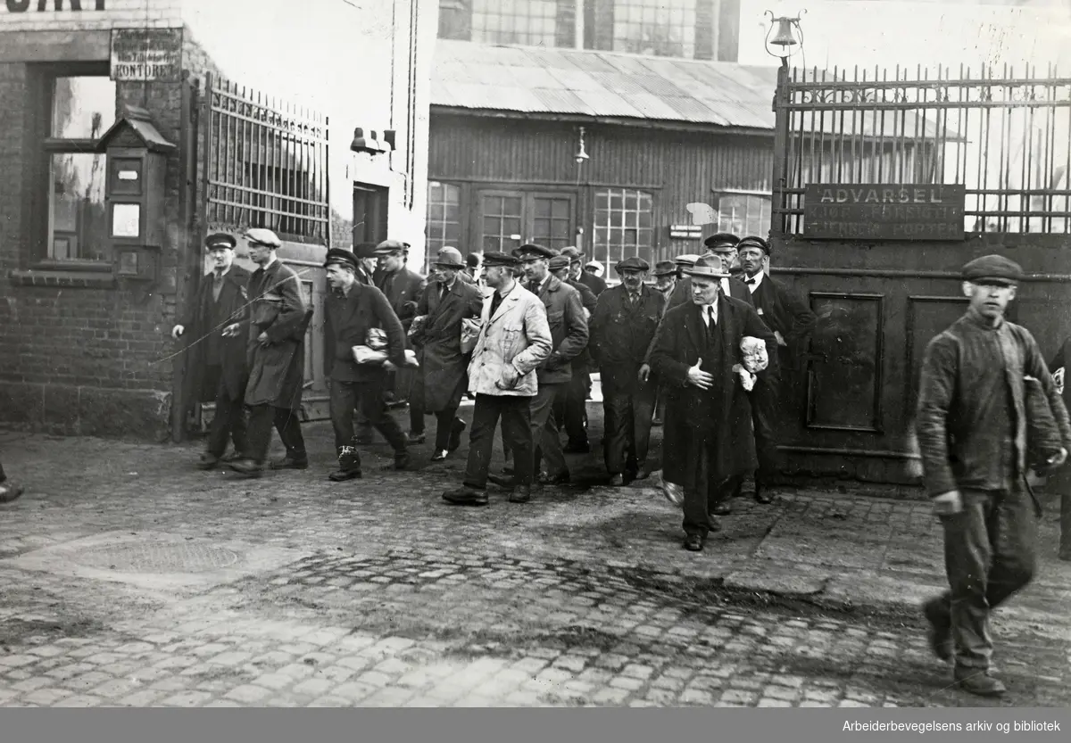 Arbeidere på vei ut porten fra Aker mekaniske Verksted, 1931.
