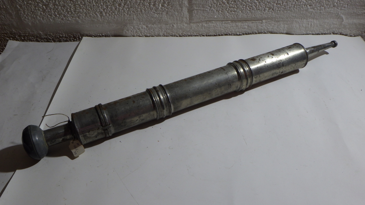 Form: Sylinder med trepumpestokk med kuleformet håndtak i enden. Konisk sprøytespiss

