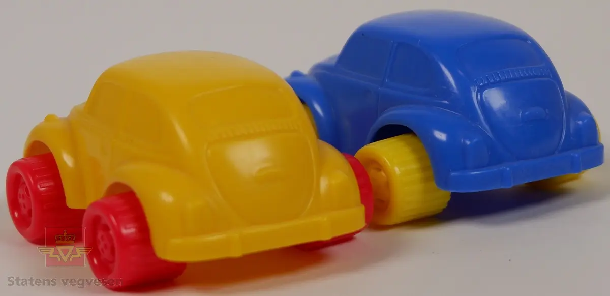 Miniatyrbiler av Volkswagen Beetle. Det er to biler i forskjellige farger, den ene er blå med gule hjul og den andre er gul med røde hjul. Bilene er laget av plast med akslinger til hjulene i metall. Innskriften FLEXI TOYS SWEDEN Made in Thailand på undersiden av bilene.