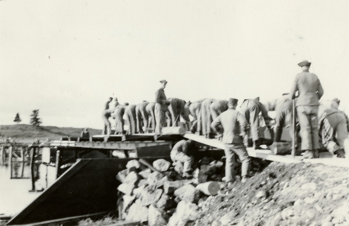 Text i fotoalbum: "Brobyggnad i Storvreta under mötet 1931. Snart började påloken bliva färdiga och då langade vi ut de tunga järnbalkarna, de största vägande 3 ton ".