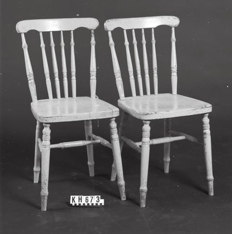 Gulmålad med delvis nedsliten färg. Vita färgfläckar på ena sitsen.
I ryggstödet sex svarvade pinnar på varje stol.