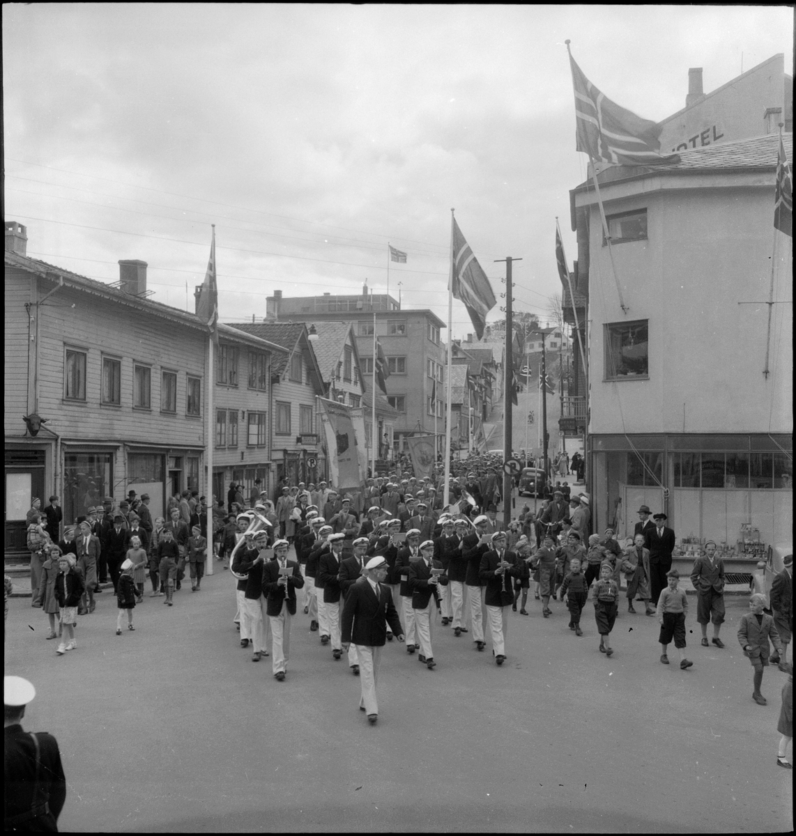 Et korps og flere sangforeninger marsjerer gjennom Egersund sentrum.