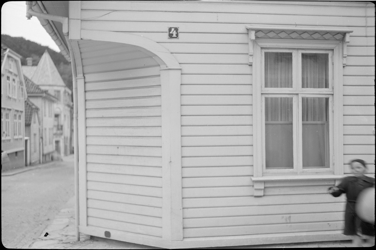 En vennegjeng i en bygate. Bilde nr. 3 er av inngangen til et hus og nr. 4 er et prøvebilde med tabeller fra en fotoforretning.