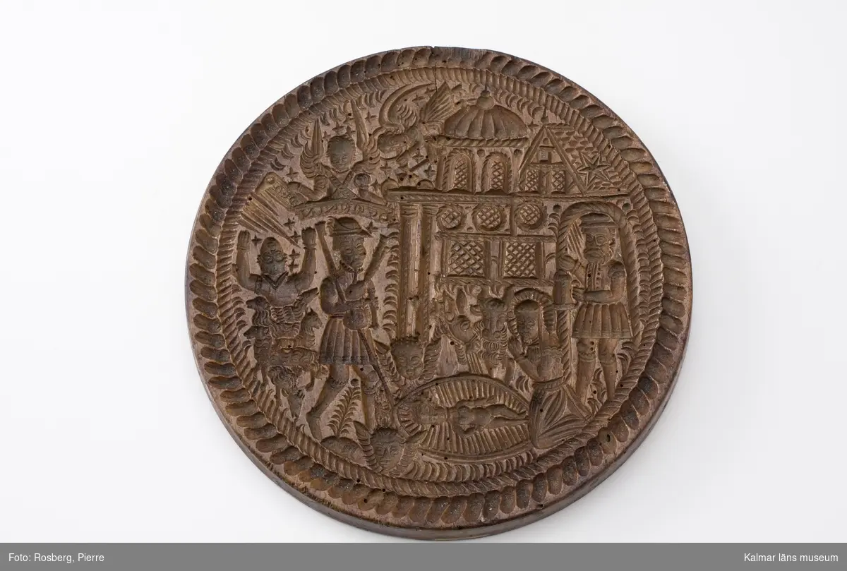 KLM 1743. Kakform. Av trä. Rund platta med rikt snidad framställning av krubban i Bethlehem. Datering: 1600-tal?