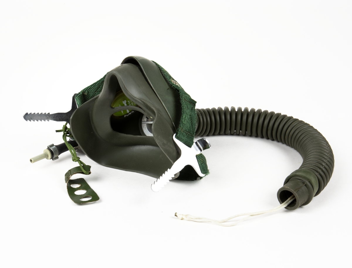 Syrgasmask med maskhållare och slang. Slangen skall kopplas till hjälmens nackblåsa.