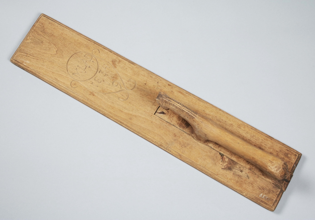 Mangelbräde i brunbetsat trä (färgslitage). Rektangulär med profilerade kanter. Handtag i hästform, skuret för sig och infällt. Utan annan dekor, än vasliknande figur med initialer och årtal: "MLAD 1834 11 9" (Gunnar Blomgren)

Mangelbräde eller kavelbräde är ett redskap av trä som använts för mangling av textilier. Mangelbrädet användes tillsammans med en kavel, en slät rulle av trä. Den textil som skulle manglas, rullades upp på kaveln, på ett bord eller annat slätt underlag. Under hårt tryck, rullades kaveln med hjälp av mangelbrädet, fram och tillbaka över bordet. (Wikipedia)
