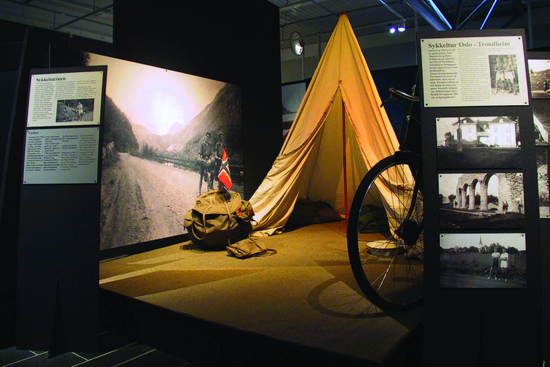 Et telt og sekk, samt noen fotografier stilt ut på Norsk vegmuseum.