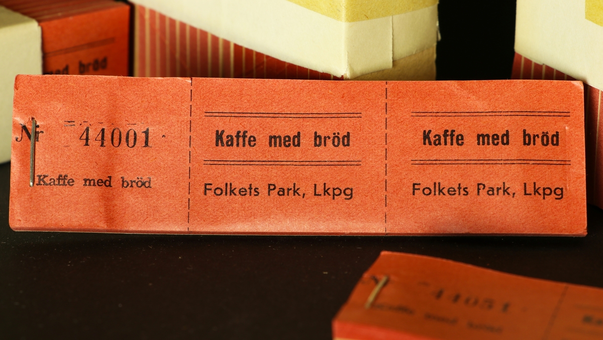 Sex buntar med häften med röda kaffebiljetter. Det är 20 häften i varje bunt. Biljetterna är röda och för kaffe med bröd i Folkets Park i Linköping. Det är vitt papper med tryckeriets logga om varje bunt, på pappret är serienumrena skrivna för hand.