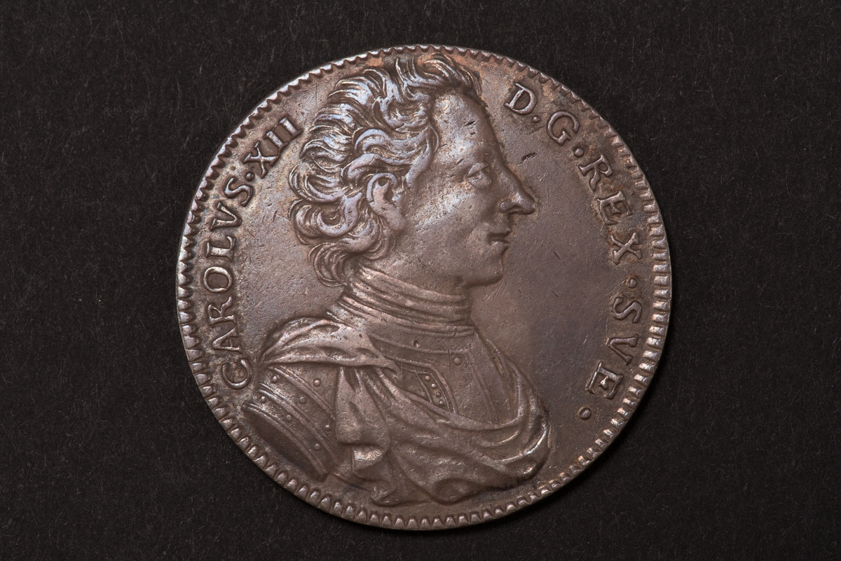 Ett silvermynt med valören 1 riksdaler.