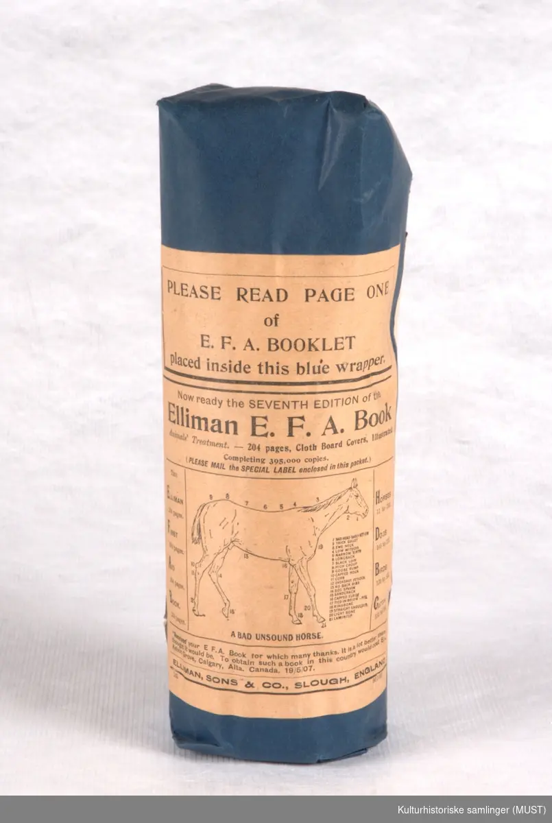 Medisinflaske, pakket inn i mørkeblått papir, med etikett festet på frem- og bakside. Uåpnet original emballsje.