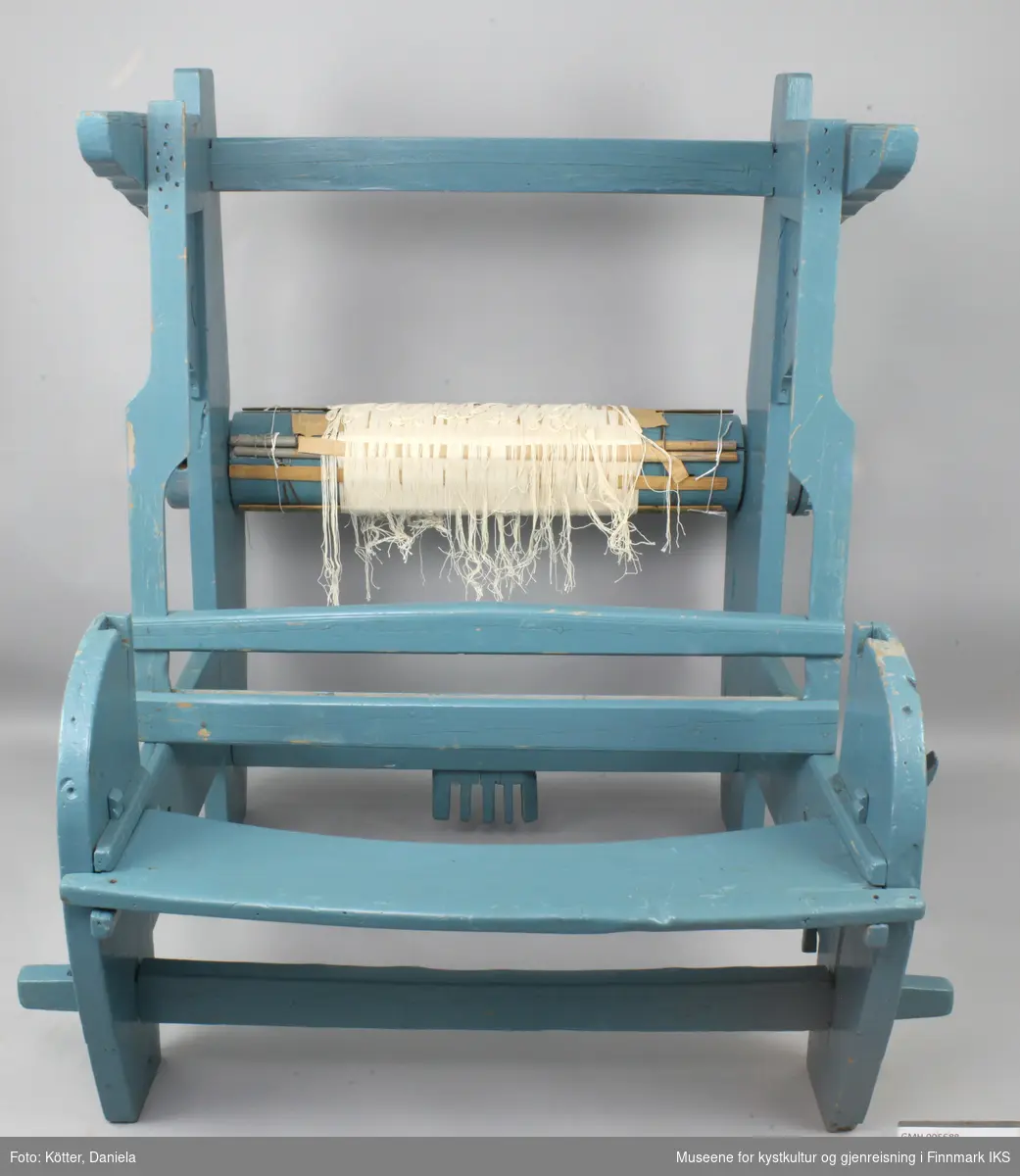 Vevstolen er bygd av tre og overflaten er overtrukket med blå lakk. Delene har slagmerker ved sammenføyningene til enklere montering. Vevstolen fremstår som fragmentarisk. Oppheng til skjeslaget, brystbom, stoffbom og mange andre vesentlige deler mangler. På garnbommen er det sveipet på renningen og spiler. Det er mulig at denne vevstolen var supplert med deler registrert som GMH.005690.