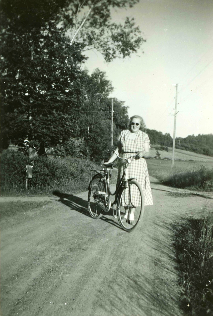 Ingrid Korneliusson Johansson (född 1940), Labacka, står med sin cykel på vägen till Tollered i Heljered 1950-tal.
