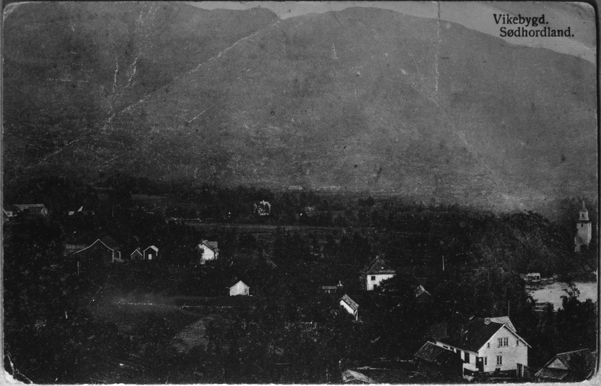Postkort med landskap frå Vikevik i Vikebygd sett mot søraust, ca. 1925. Vikebygd kyrkje heilt til høgre i biletet. Husafjellet i bakgrunnen
