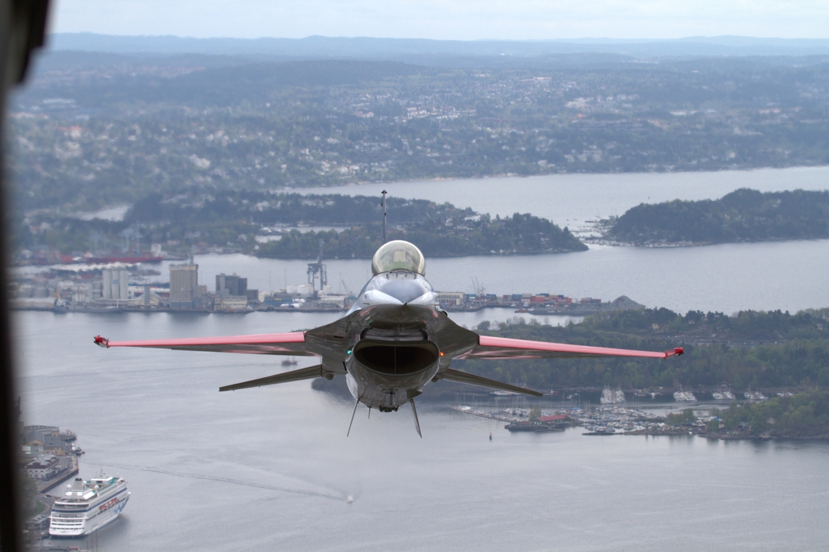 F-16A, fløyet av testflyger Maj. Eskil Amdal, fotograferes fra C130J 09. mai 2012. Flyet er lakkert i det norske flaggs farger i forbindelse med 100 årsjubileumet for norsk militær luftmakt.