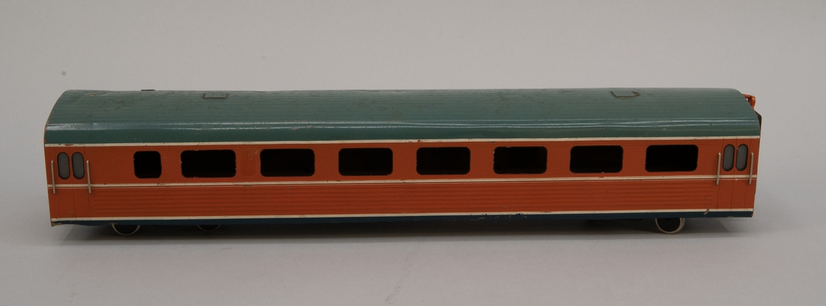 Modell i skala 1:50 av motorvagn UBoa2, X9M. Mellanvagn.
Orange med vita linjer och grågrönt tak.