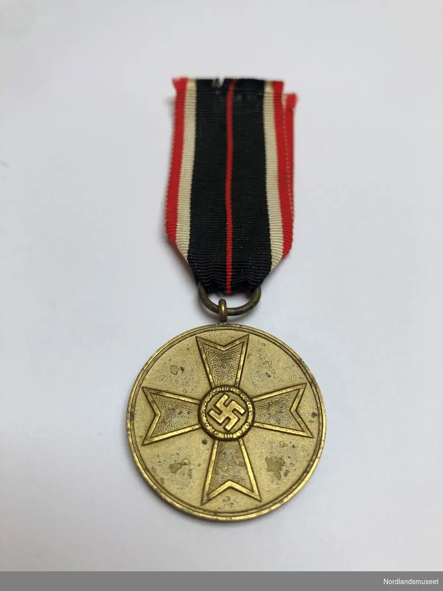 Forsiden av medaljen har et malteserkors med hakekorset i midten, og på baksiden står det stemplet «Für krigsverdienst 1939» (For krigsfortjeneste 1939).