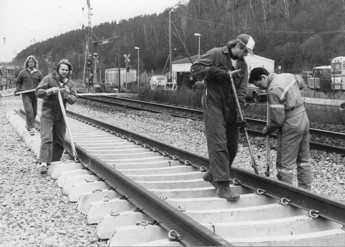 Utbyggnad för pendeltåget 11 april 1990. Vy norrut på fyra män som utför utläggning av nya järnvägsspår, Torrekulla i Kållered.