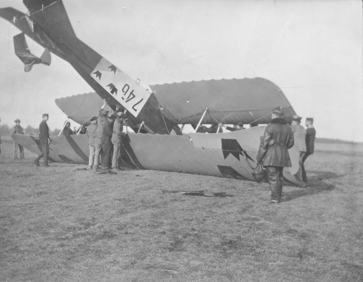 Flygplan SW 20 Albatros nummer 746 har landat upp- och ned vid ett haveri. Militärer arbetar med att vända på flygplanet.