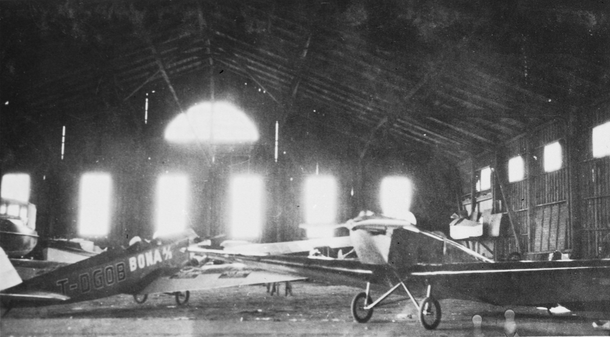 Danskregistrerat flygplan Klemm-Daimler L 20 märkt T-DGOB står i en hangar tillsammans med ett annat civilt flygplan, 1928-1929.