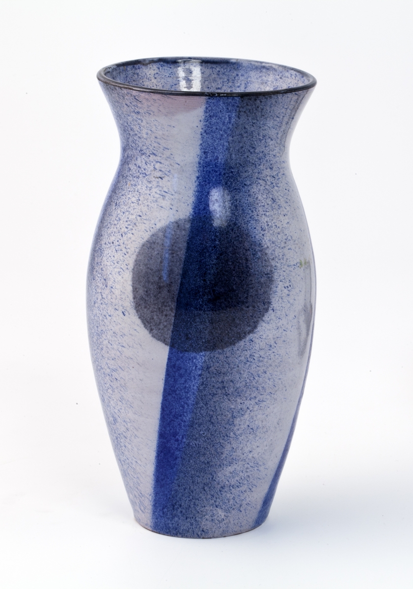 En elegant og sklank vase hvis dekorvirkning oppstår av fire glasurfelt , hvor glasuren toner fra dyp blå til lys violett, nesten med et rosa skjær. Dette repeteres i hvert felt. Underglasuren er gråaktig og er sprøytemalt på korpus. Den toner fra mørk til lys. Den har klare ovrglasureer, som skaper dekorvirkningene i glasuren.  På  hver side av vasen, i skjæringspunktet mellom to glasurfelt, er det en grå sirkel.