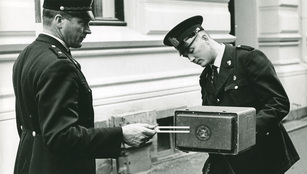 To politimenn kalibrerer en radar ved hjelp av stemmegaffel.