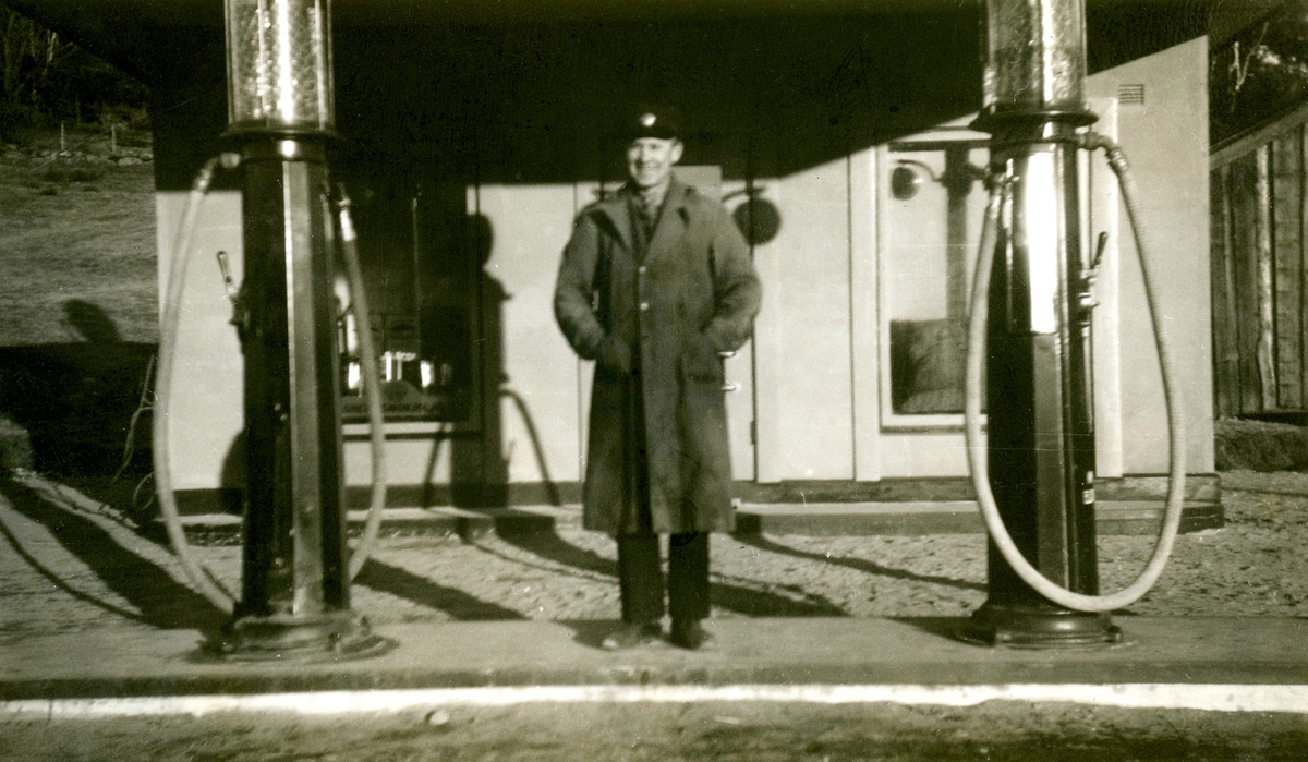 Troligtvis John Johansson (1898 - 1966) från Nygård, busschaufför för Kållered Bussbolag, står mellan två bensinpumpar vid Caltex Texacostation, 1940-tal. Bensinstationen låg vid nuvarande Streteredsvägen och Gamla Riksvägen i Kållered centrum.