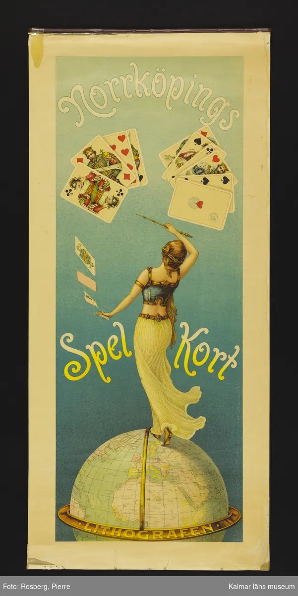 KLM 23970:37. Reklamaffisch. Text: Norrköpings Spelkort Litografen. Bild: En kvinna med en stav i ena handen står på en jordglob och bredvid och över henne ett antal spelkort.