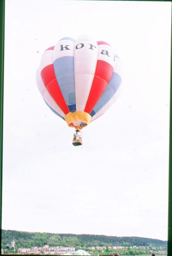 En röd-blå-vit ballong, möjligen märkt "KORAL" i luften.