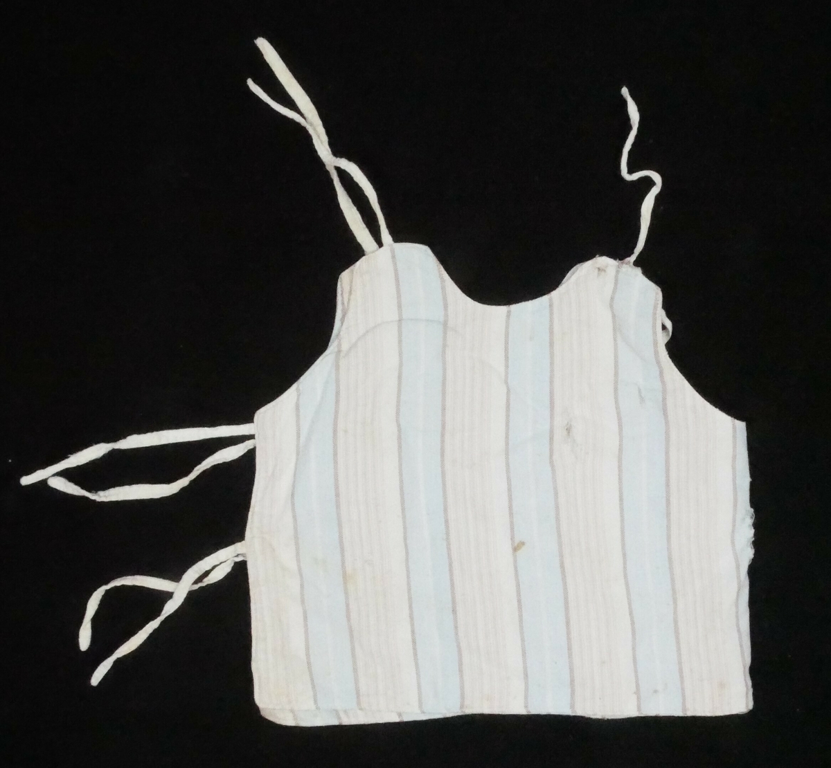 Ermelaus skjorte med rund hals og fire tråder til knyting i siden og på skuldrene. 