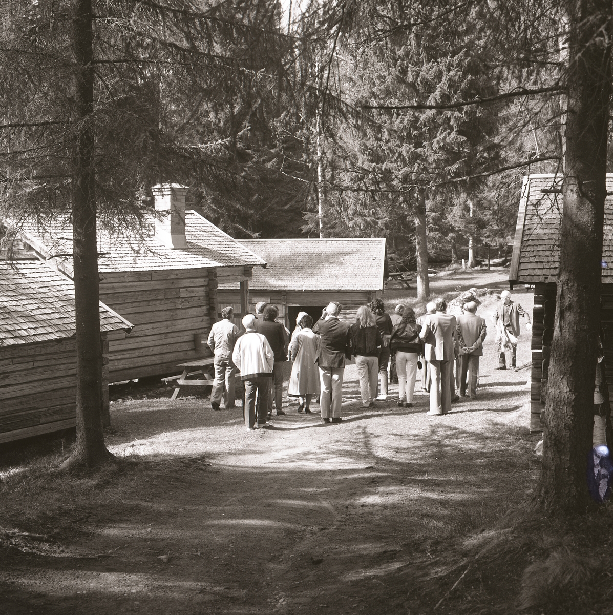 Ett sällskap får en guidad vandring bland härbren och bodar i Trolldalen, Växbo.