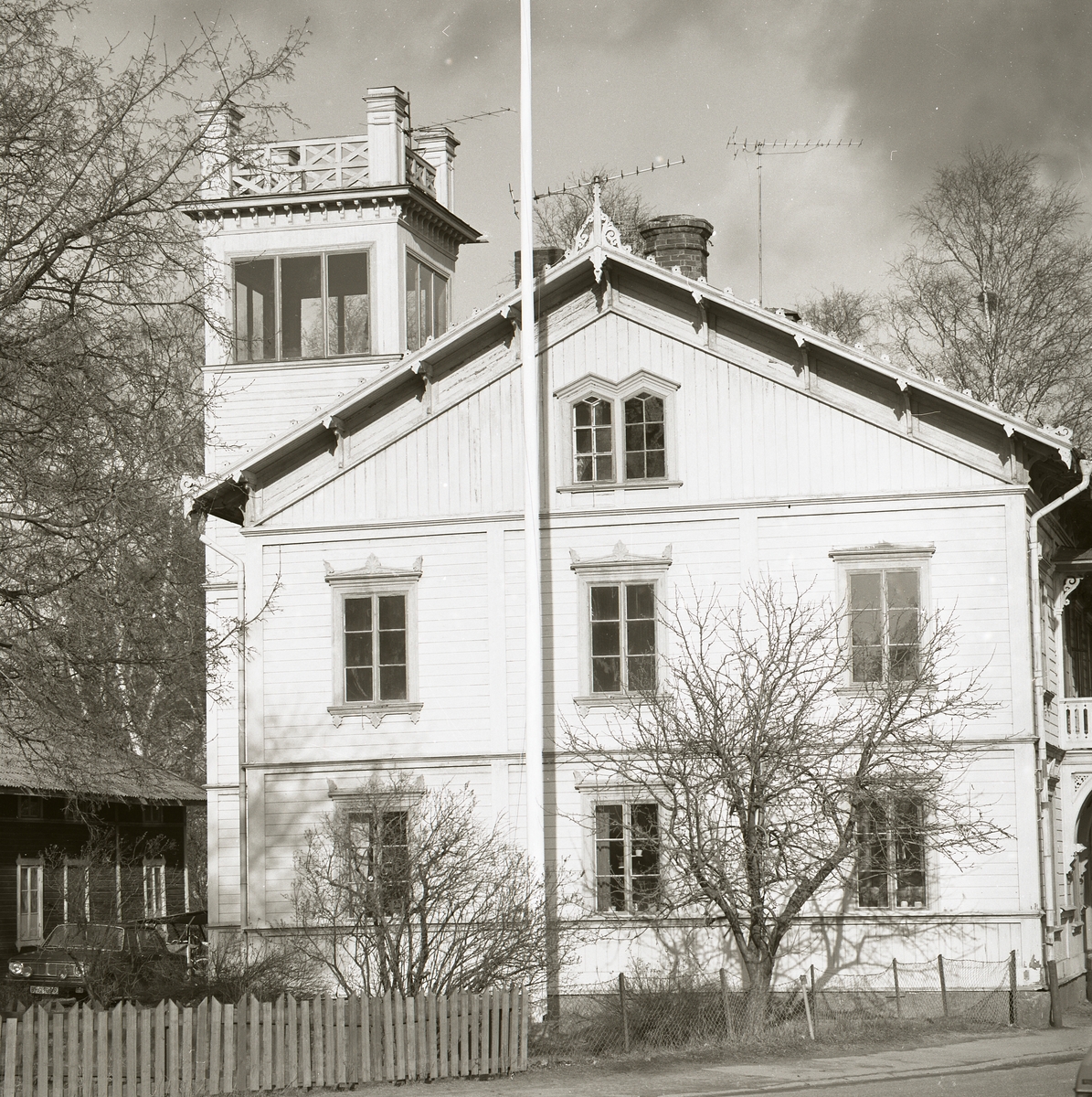 Ett stort boningshus av trä med fina detaljer runt fönster och tak, samt en tornbyggnad, Ljusdal 1982.