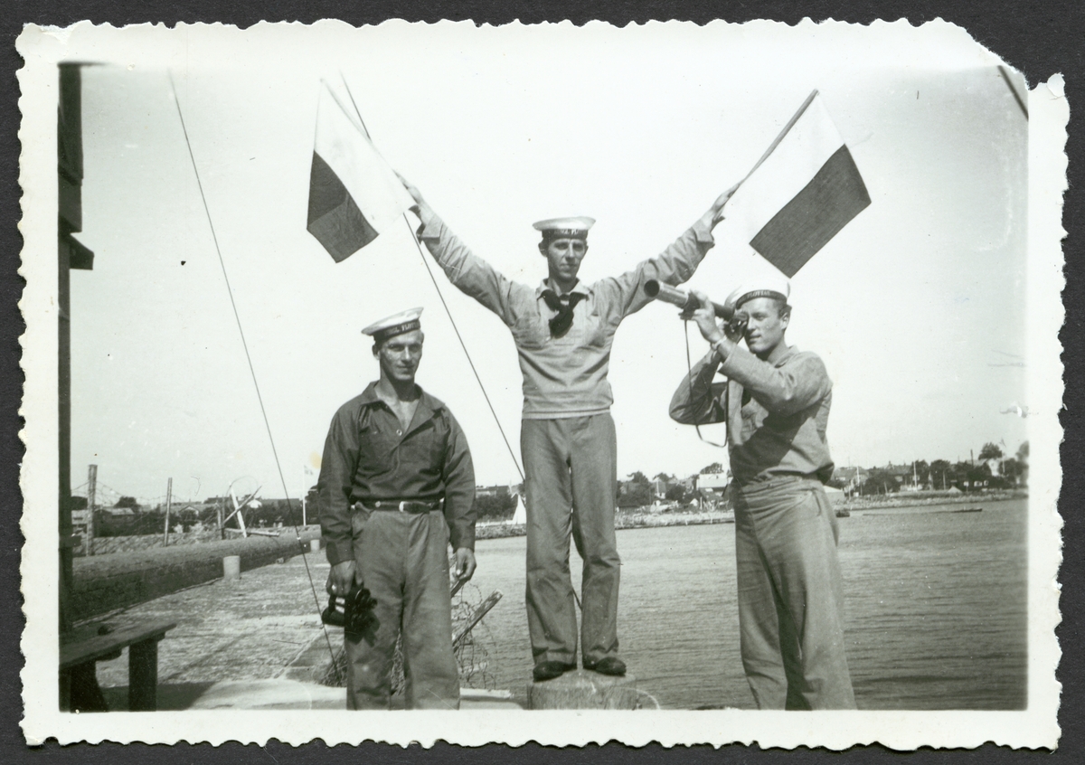 Bilden visar Gösta och två andra sjömän som hanterar med signalflaggor och kikare.