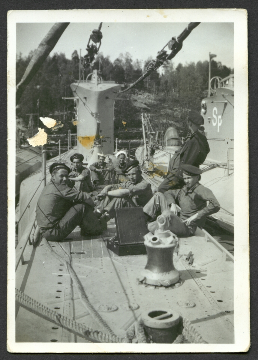 Bilden visar en grupp sjömän som ta en rast på däck av ubåten Delfinen.