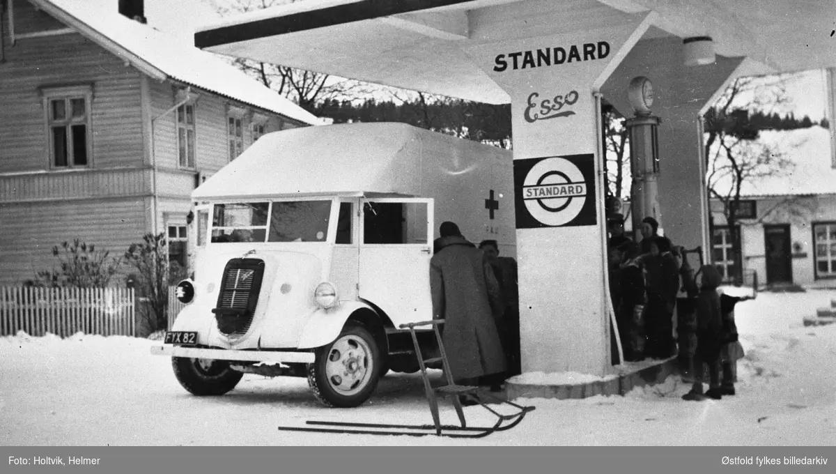 Røde Kors-bil som er underveis til Finland under stopp på bensinstasjon i Ørje, Marker 1939. Bil av merket engelsk Ford lastebil modell 7V 1937-39, bilkjennetegn FYX 77,
Reklame for Standard Esso.