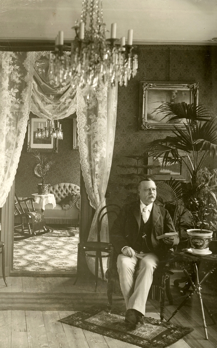 Kassören Carl Berg i sitt hem beläget i hörnet av Drottningatan och Snickaregatan i Linköping. Född och uppvuxen i Stockholm hade han inflyttat till Linköping år 1870 för tjänst som bokhållare vid Asklundska tobaksfabriken, en anställning han innehade till företagets nedläggelse 1908.