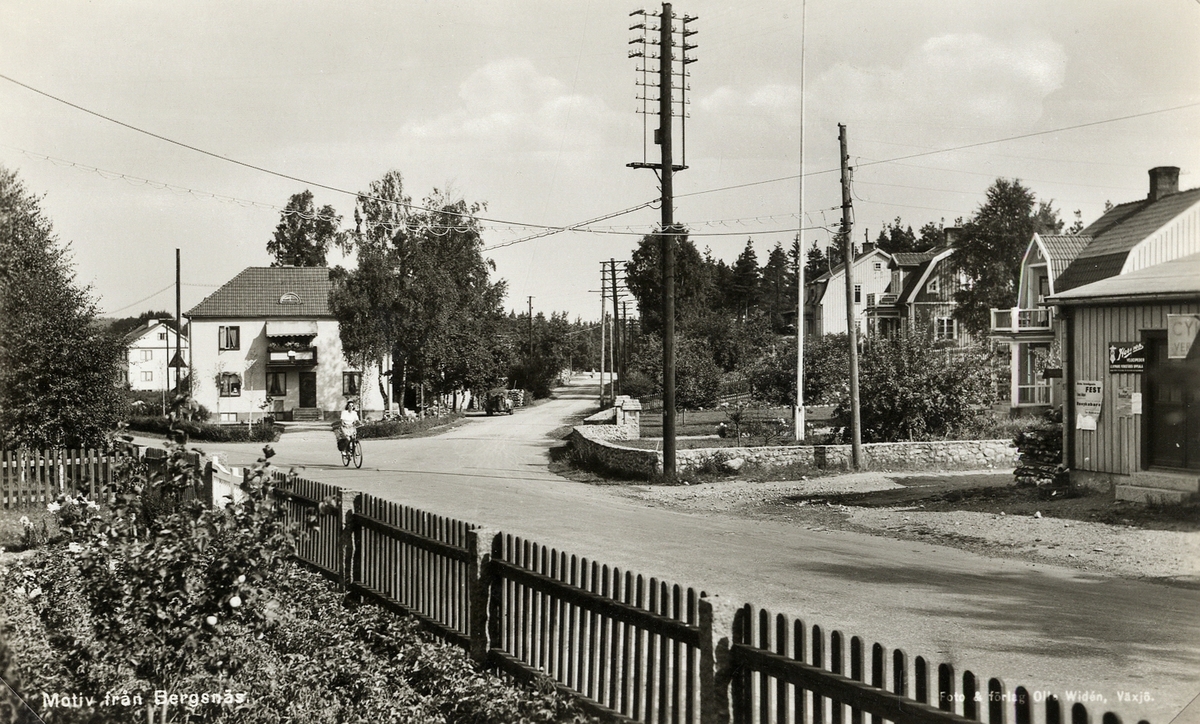Bergsnäs, Växjö, ca 1945. En kvinna cyklar vägen fram vid en affär.