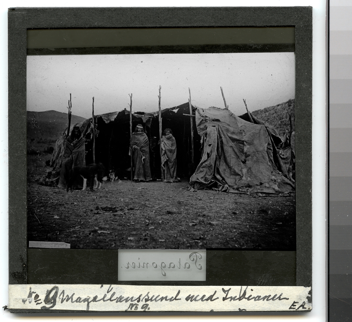 Bilden visar tre urinvånare från Patagonien som har tagit uppställning framför sin tält, en toldo, för fotografering.