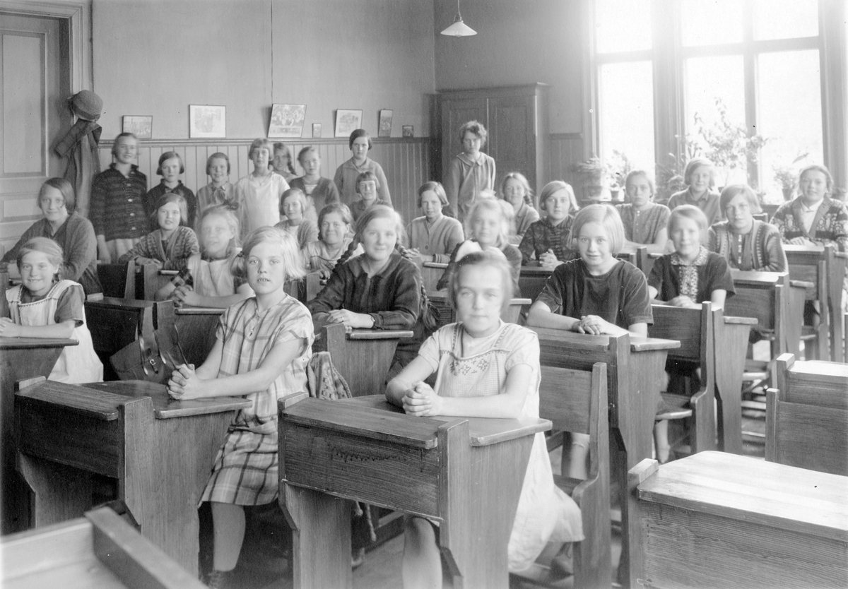Centralskolan. Lärarinna och flickelever i ett klassrum.