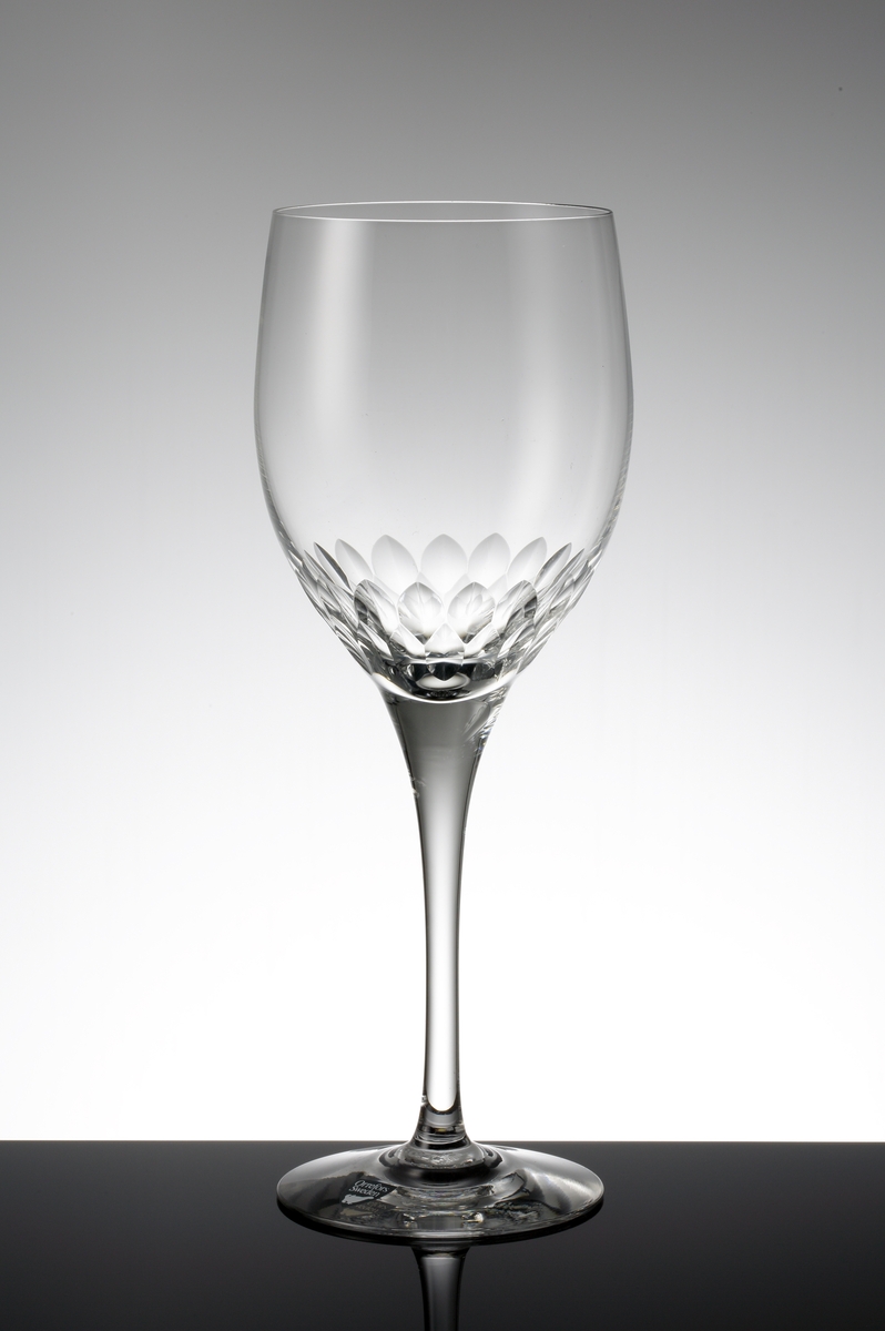 Design: Nils Landberg.
Ölglas. Tulpanformad kupa med fjällslipning på nedre delen. Högt, draget ben. 
Fabriksmärke: mörkgrå botten med vit text.